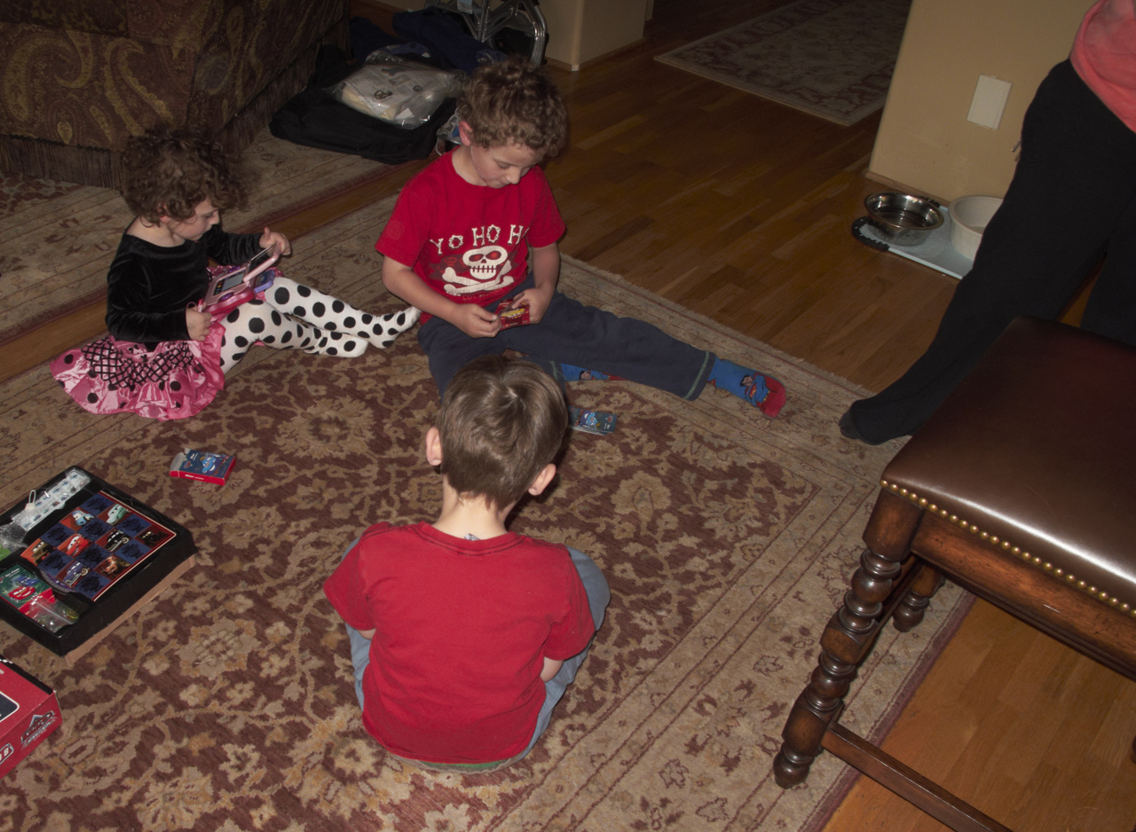 Sophia, John, and James playing with their new toys, while Adele looks on